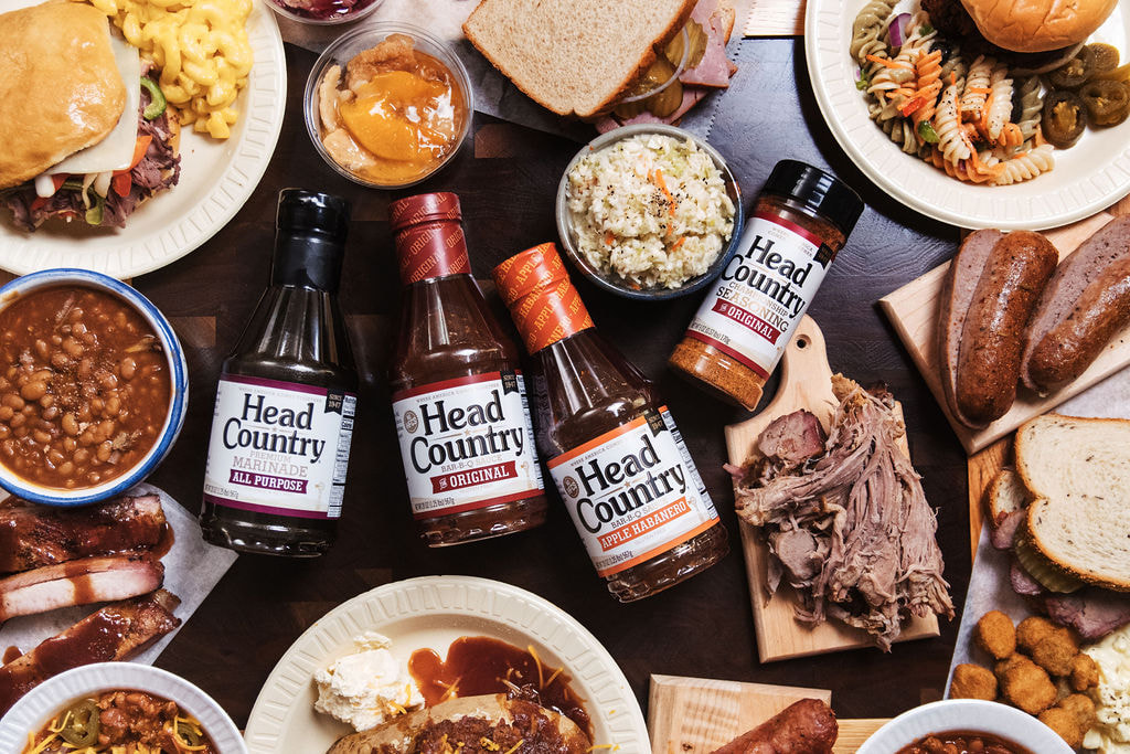 Head Country sauces and seasonings beside a plate of smoked meat